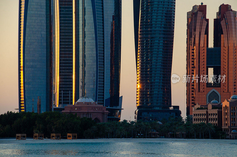 阿布扎比滨海大道(Abu Dhabi Corniche Road)玻璃酒店上的日出倒影。